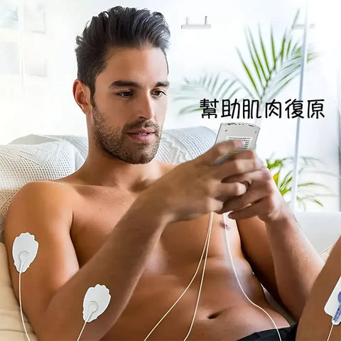 A focused man with a beard using a handheld TENS (Transcutaneous Electrical Nerve Stimulation) device, with electrode pads attached to his chest and arms, in a home setting with plants in the background