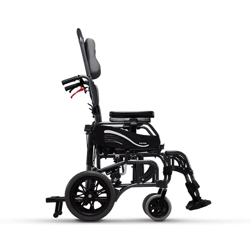 A side view of a black reclining wheelchair showcasing its profile, with an adjustable headrest, flip-back armrests, and elevating leg rests. The design indicates a focus on ergonomics and comfort, with a solid frame and large rear wheels paired with smaller front casters for smooth mobility.