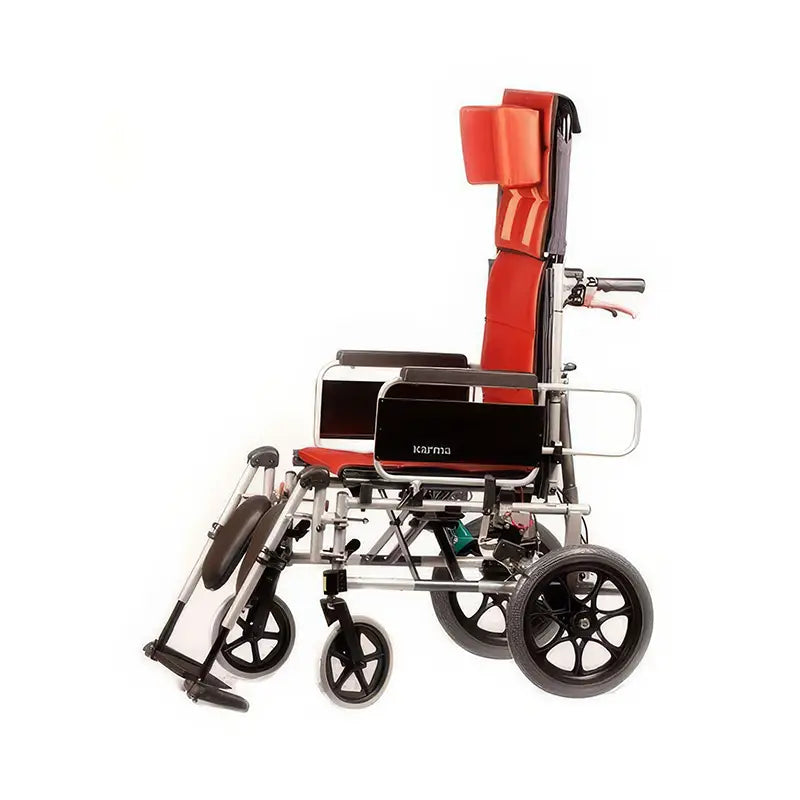 This image shows the KM-5000 F14 wheelchair in a side view. The wheelchair has a silver frame with red cushioning for the seat, backrest, and headrest, offering ample support and comfort. The backrest is reclined, demonstrating its adjustable feature. The large rear wheels and smaller front wheels ensure smooth maneuverability. The design is lightweight yet sturdy, suitable for daily use and easy transportation.