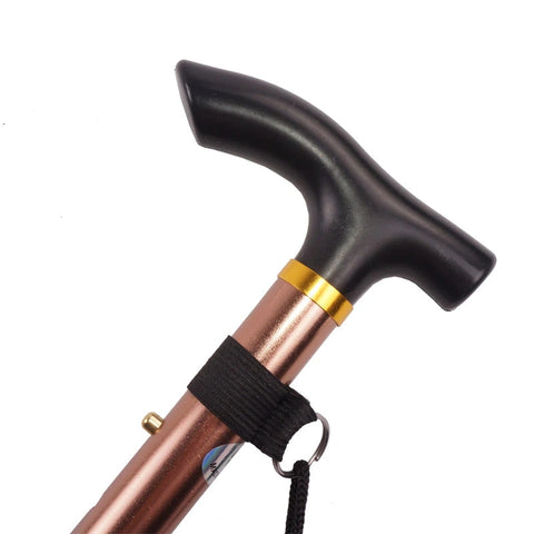  It features a comfortable ergonomic black handle, designed to fit the natural grip of a hand, and a stylish copper-colored shaft with a sleek metallic finish. A gold-colored band adds a touch of elegance between the handle and the shaft. The walking stick also includes a black wrist strap for convenience and safety, ensuring it doesn’t slip from the user's grasp. This design combines functionality with aesthetics, providing support with a fashionable look.