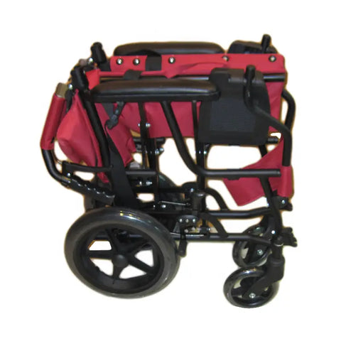 A folded red and black Masar Ma-34 manual wheelchair, showing its compact and portable design. The wheelchair features large rear wheels and smaller front wheels, with a sturdy frame that allows for easy folding and storage. Designed for convenient transport, this lightweight manual wheelchair is ideal for users needing mobility on the go.