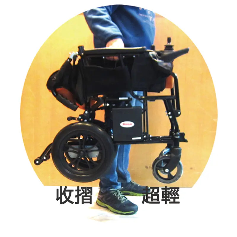輪椅展示示範：一名穿著牛仔褲和運動鞋的人站在摺疊後的美國Masar美莎MA-9輕便電動輪椅旁，顯示了輪椅的便攜性和摺疊功能。