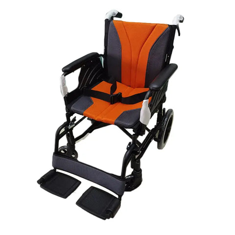 foldable wheelchair designed for enhanced mobility. The wheelchair features a sleek black frame with contrasting bright orange accents on the seat and backrest for a visually appealing look. It includes padded armrests, adjustable footrests, and safety straps to ensure comfort and security. The wheelchair also has large rear wheels for easy maneuvering and smaller front wheels that aid in stability.